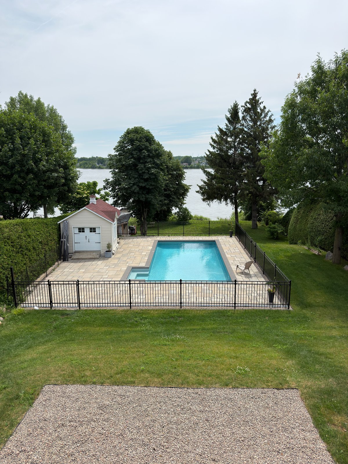 Clôture ornementale en aluminium noir autour d'une piscine creusée en bord de l'eau