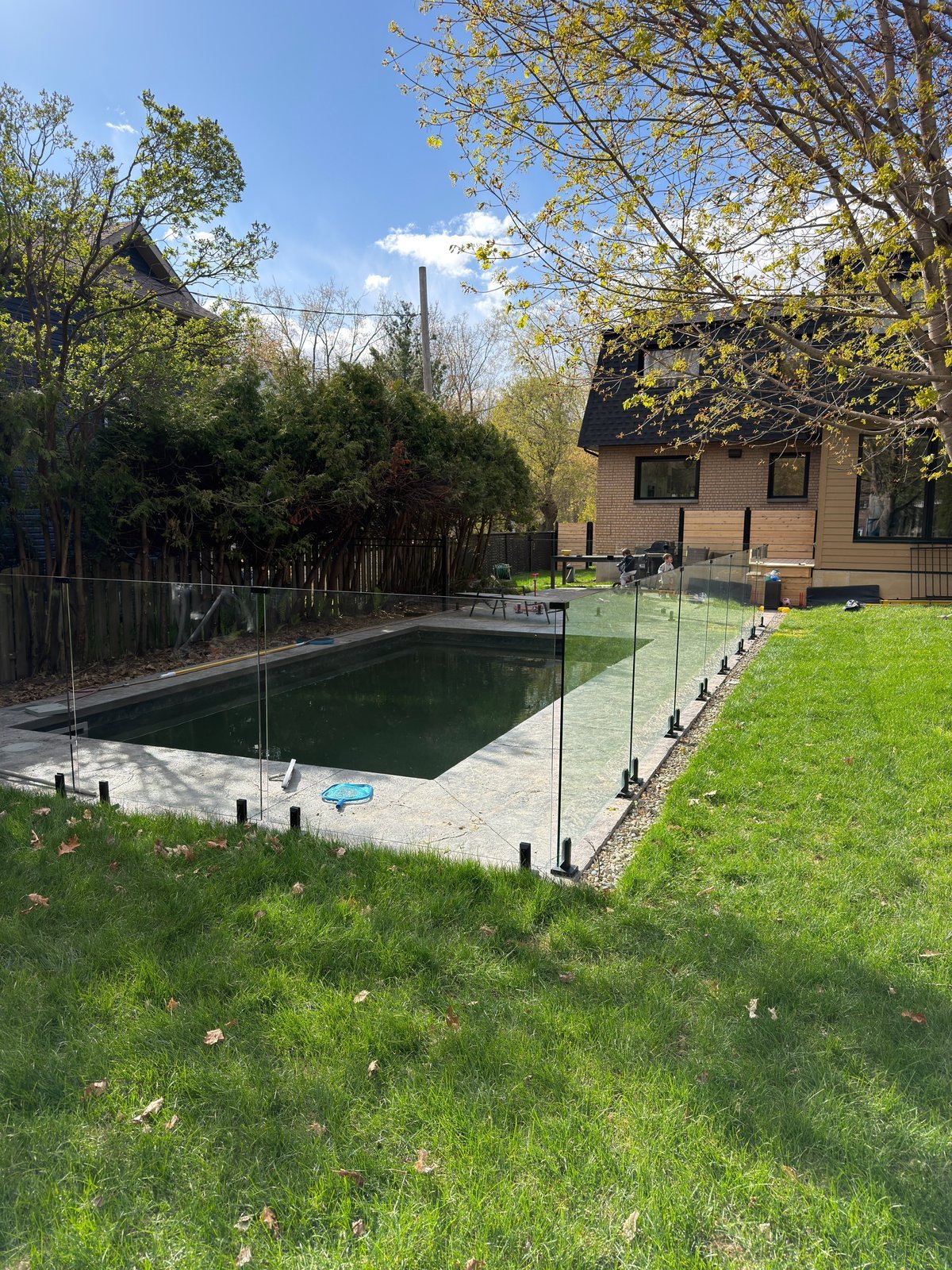 Enceinte de piscine en verre trempé sans cadre installée autour d'une piscine creusée